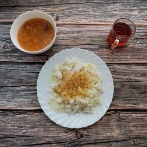 Zdjęcie przedstawia Dietę podstawową: Kapuśniak z kapusty kiszonej Ryż na sypko Mus z jabłek prażonych Sos budyniowy o smaku śmietankowym Kompot owocowy z jabłkami